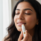 Woman applying a lip balm with a blurred background
