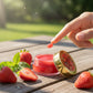 Lip balm with strawberries on a wooden surface