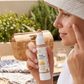Woman applying sunscreen with a bottle of sunscreen on a patio